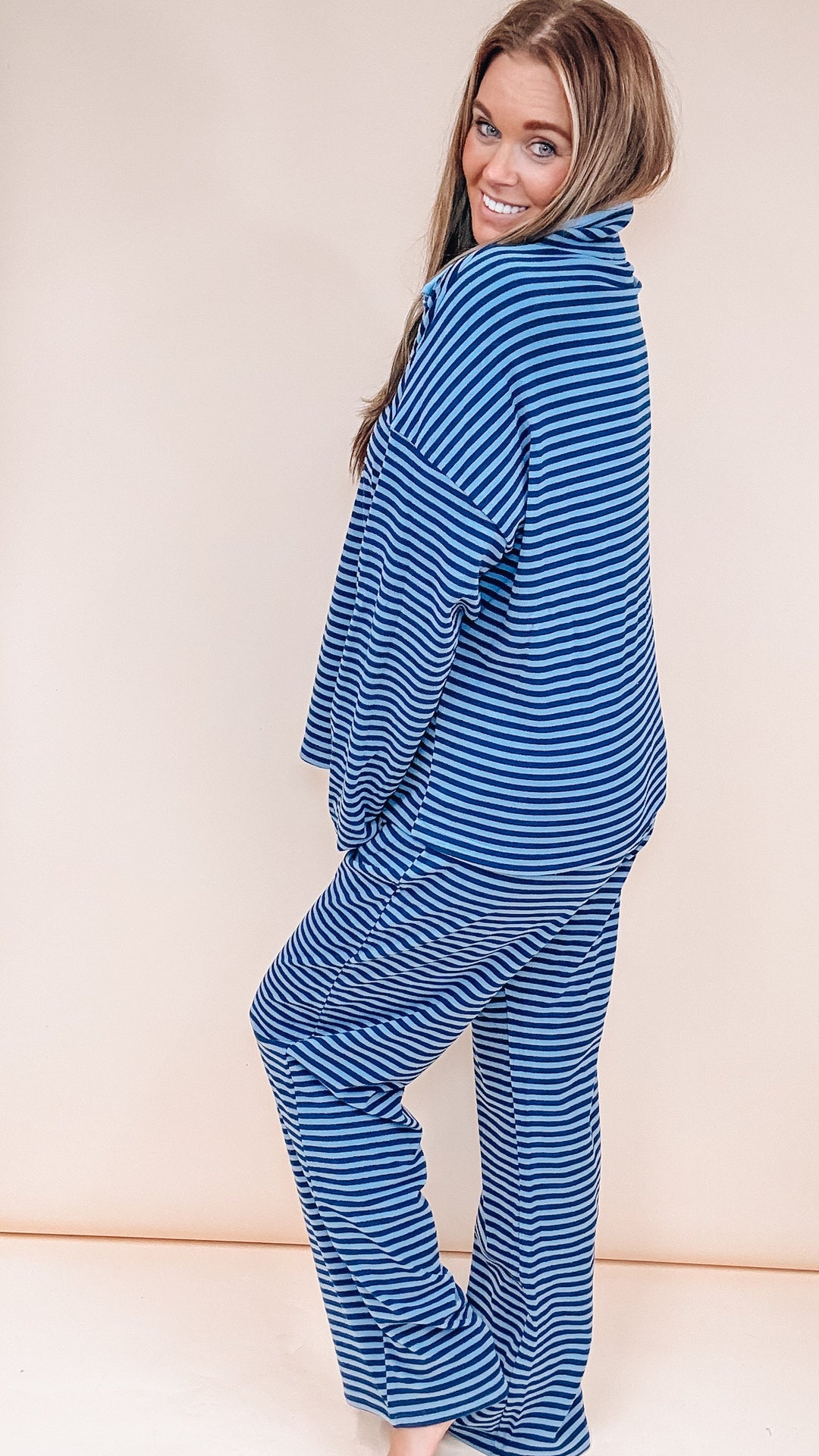 Woman wearing matching stripe set on plain background