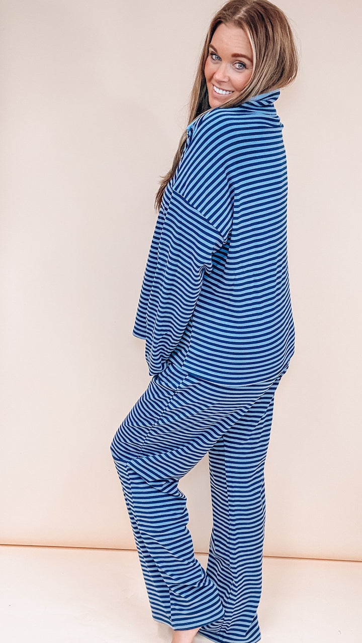 Woman wearing matching stripe set on plain background