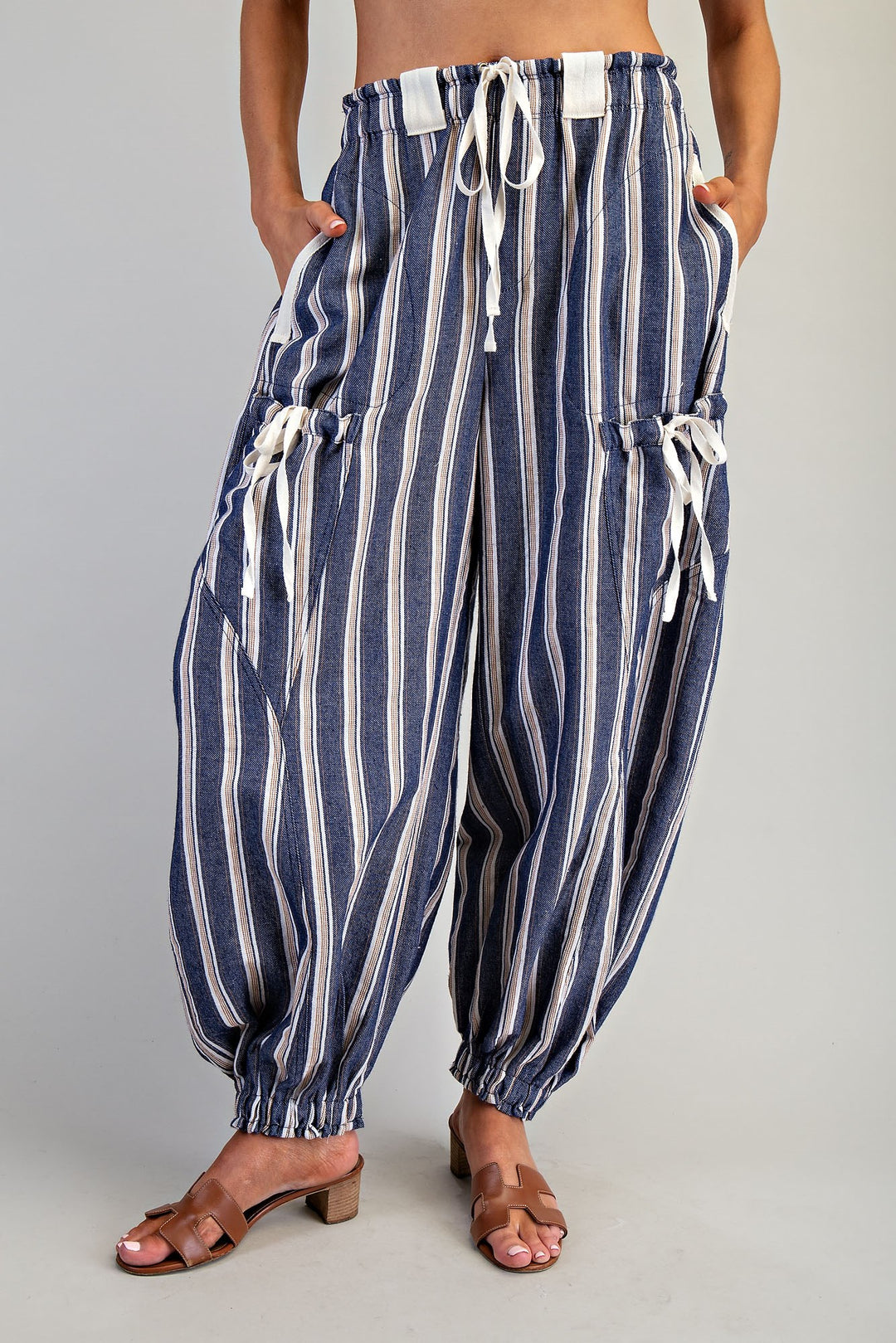 Woman wearing blue stripe pants on plain background