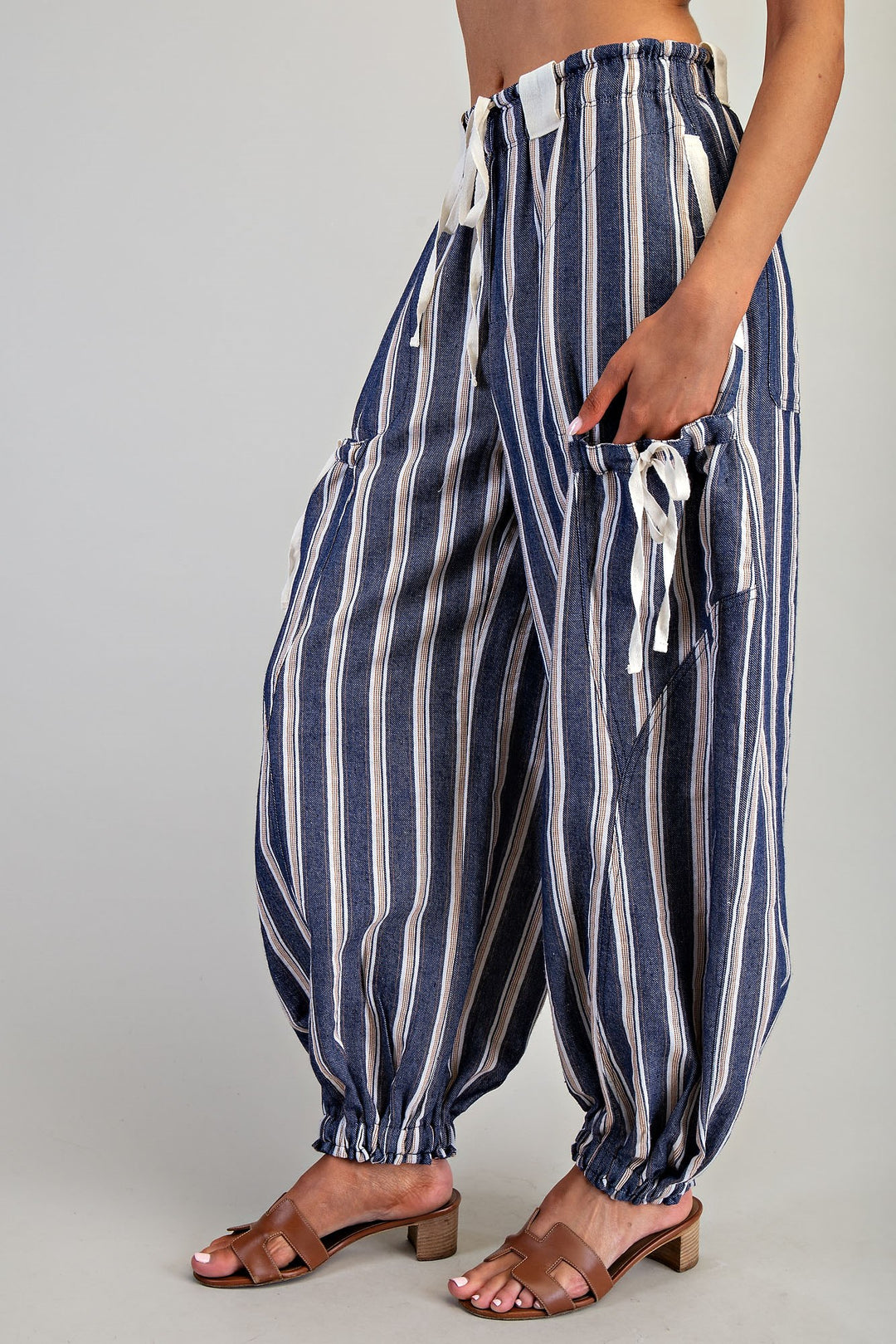 Woman wearing blue stripe pants on plain background