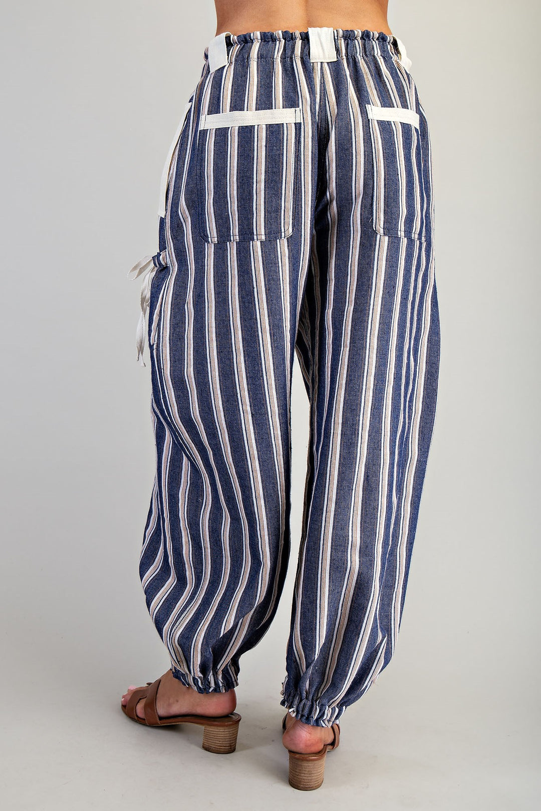 Woman wearing blue stripe pants on plain background