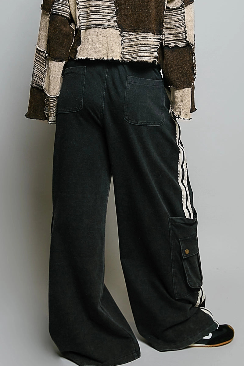 back of person wearing black cargo pants on plain background