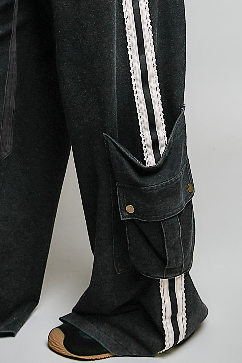 close up of black cargo pants on plain background