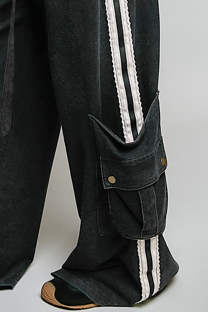 close up of black cargo pants on plain background