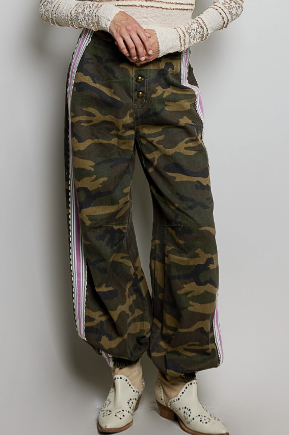Woman wearing camo pants on plain background