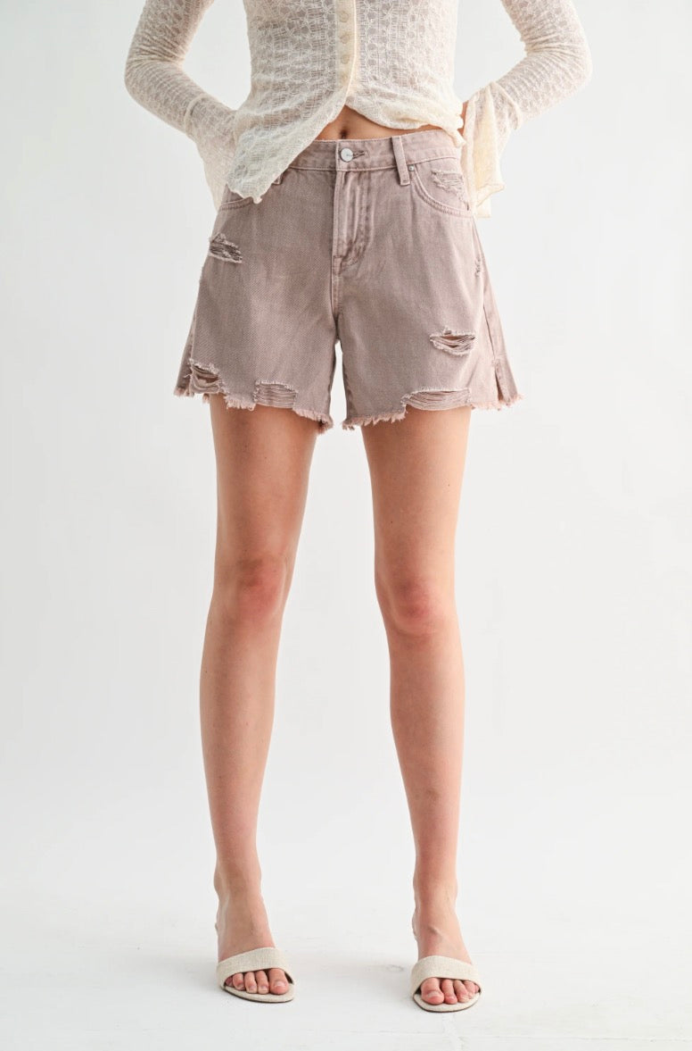 Person wearing light-colored denim shorts on a white background