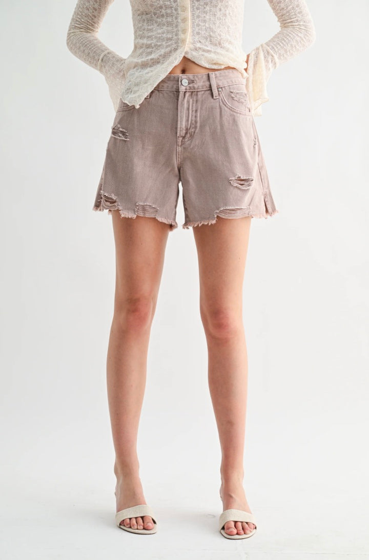 Person wearing light-colored denim shorts on a white background