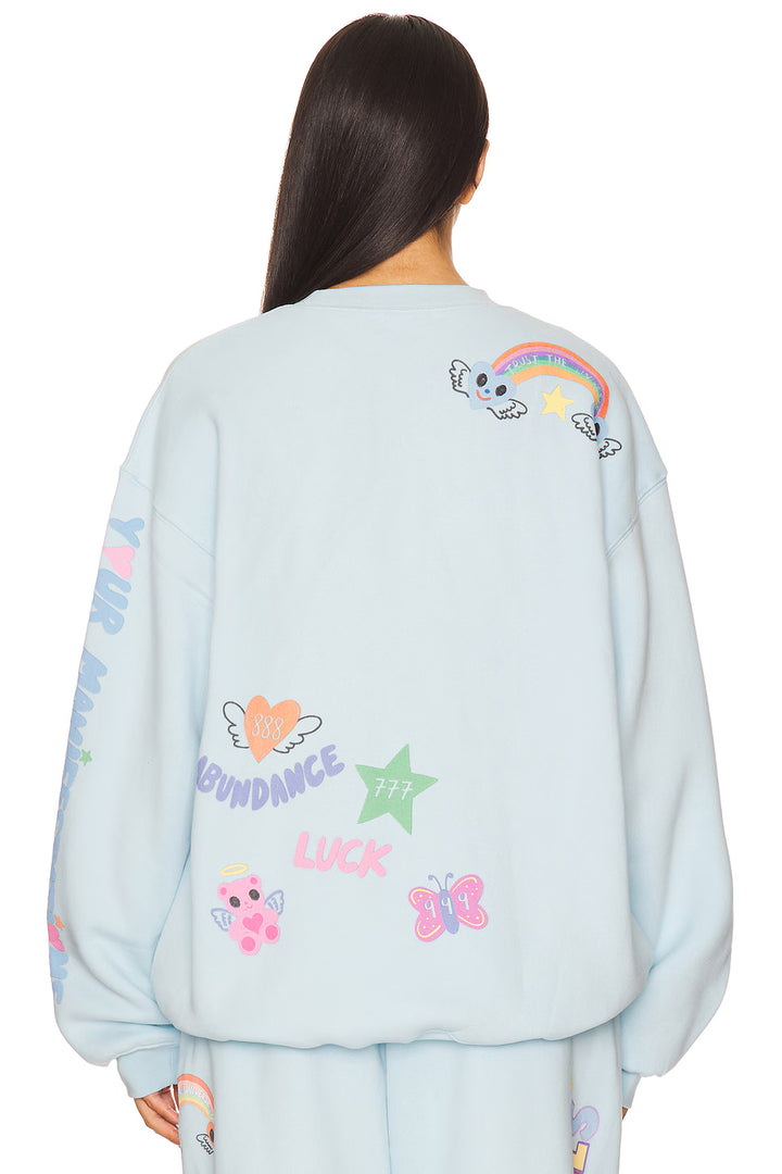 Light blue sweatshirt with colorful designs and text on a white background