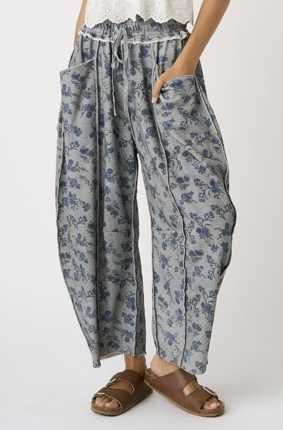 Woman wearing grey floral pants on white background