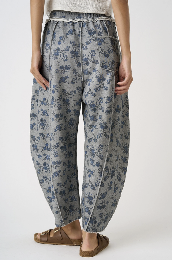 Woman wearing grey floral pants on white background