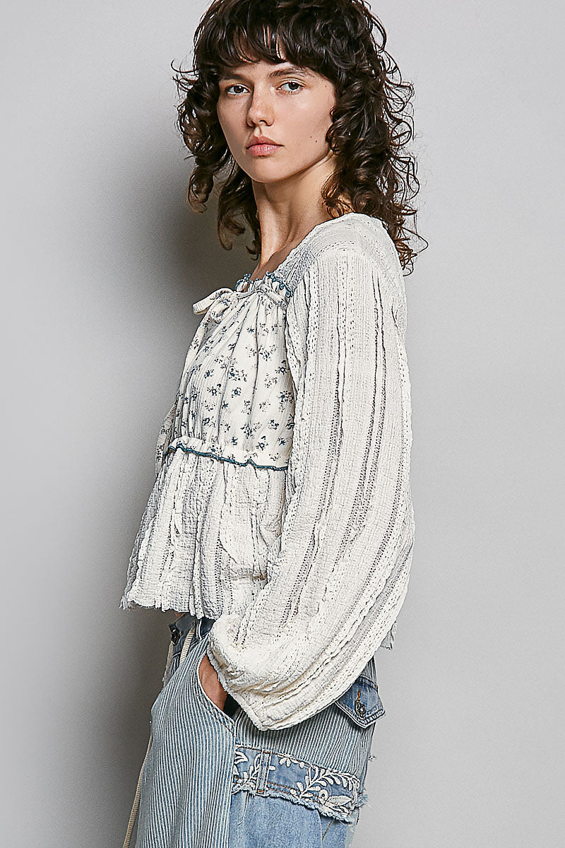 Woman wearing a white lace top with a gray background