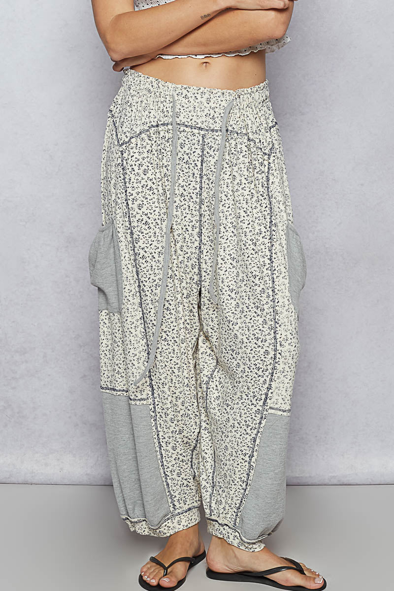 Floral patterned pants worn by a person on a plain background