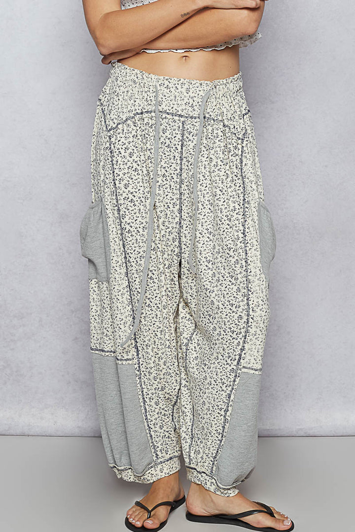 Floral patterned pants worn by a person on a plain background