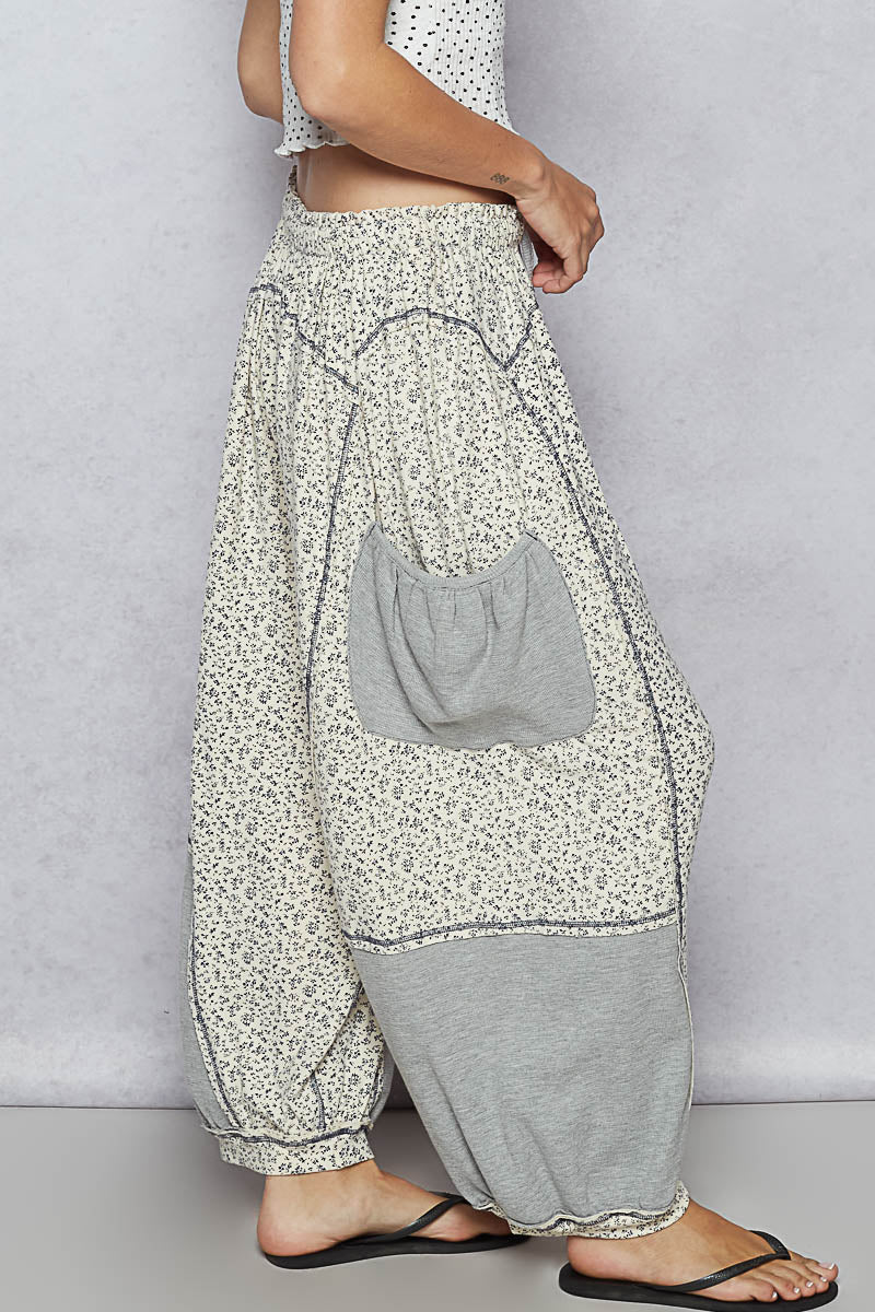 Floral-patterned harem pants with a gray patch on a plain background