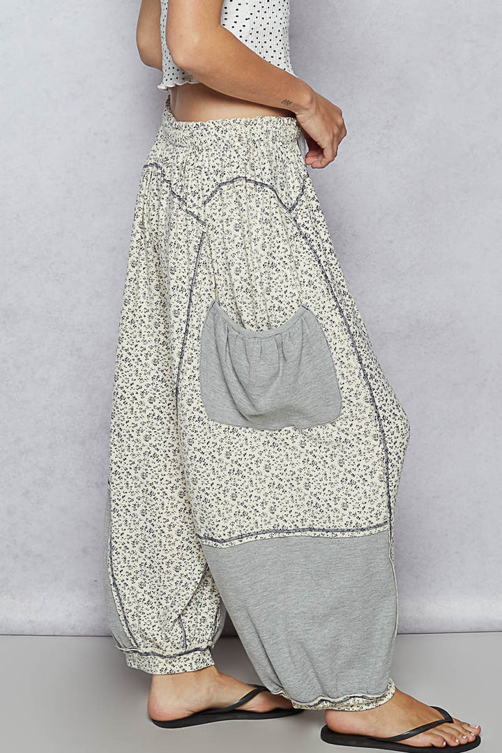 Floral-patterned harem pants with a gray patch on a plain background
