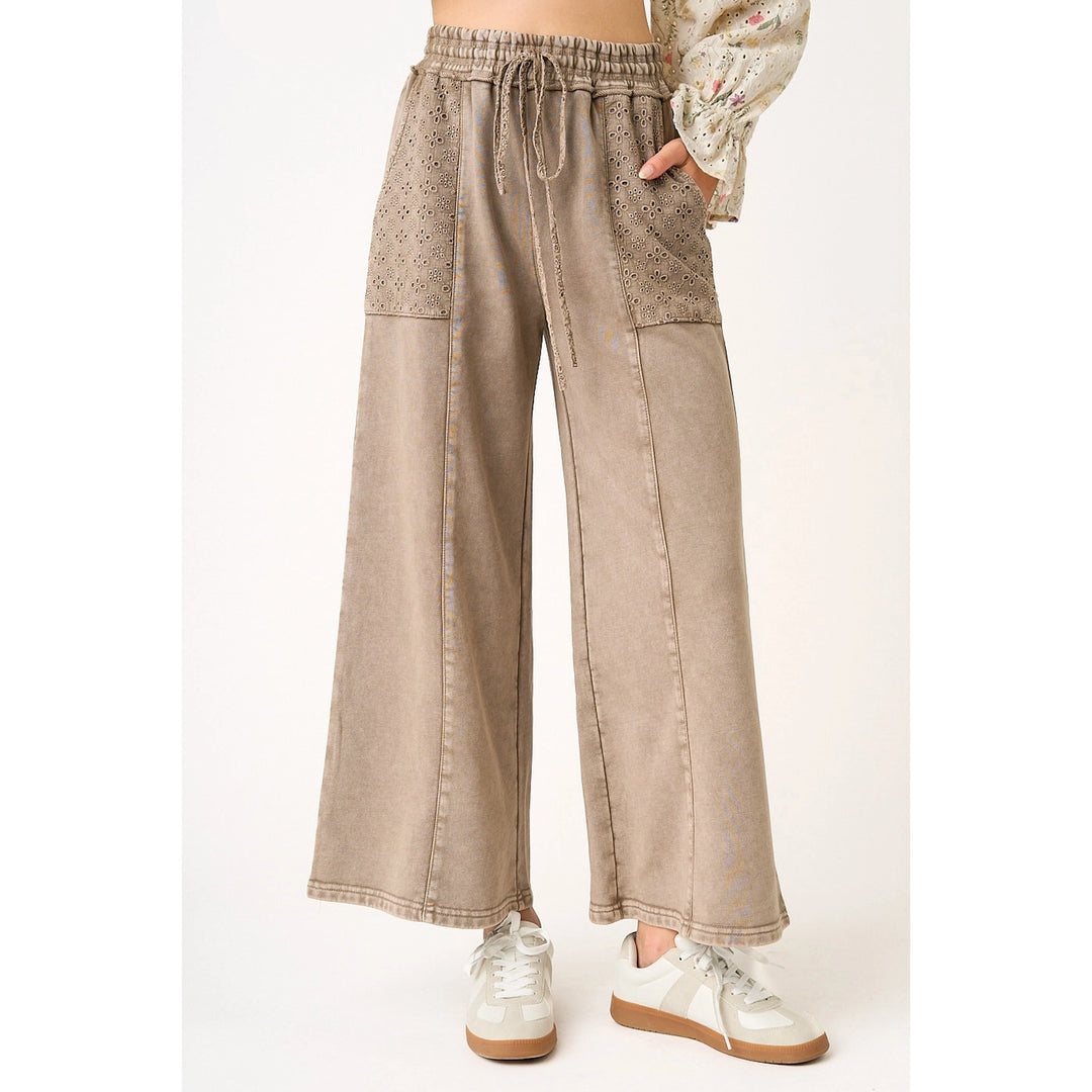 woman wearing mocha pants with eyelet pockets on plain background