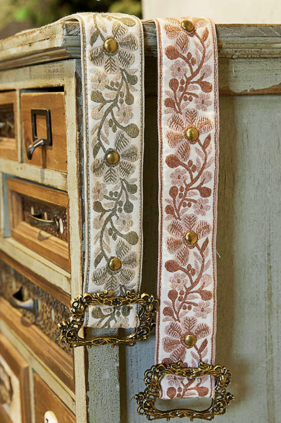 Decorative belts with floral patterns on a wooden surface