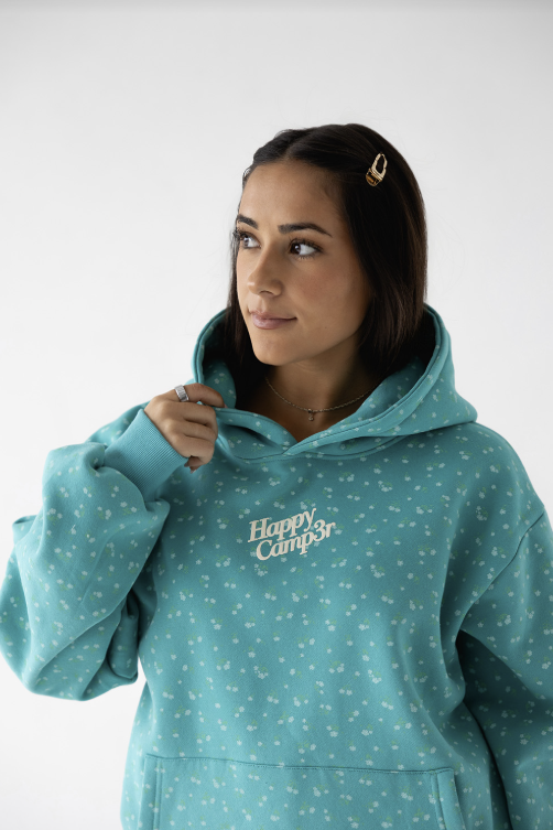 Person wearing a teal hoodie with &
