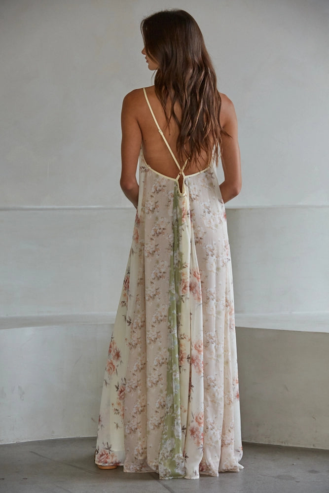 Back of woman wearing floral print dress on plain background