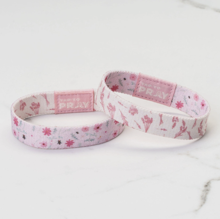 Two pink floral-patterned headbands on a white surface