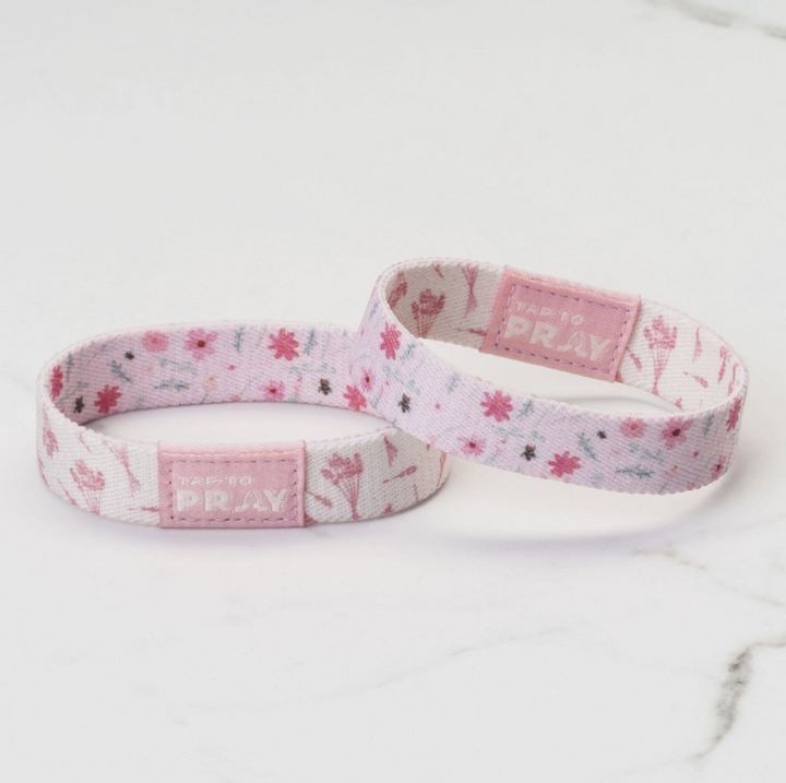 Two pink floral-patterned wristbands with &