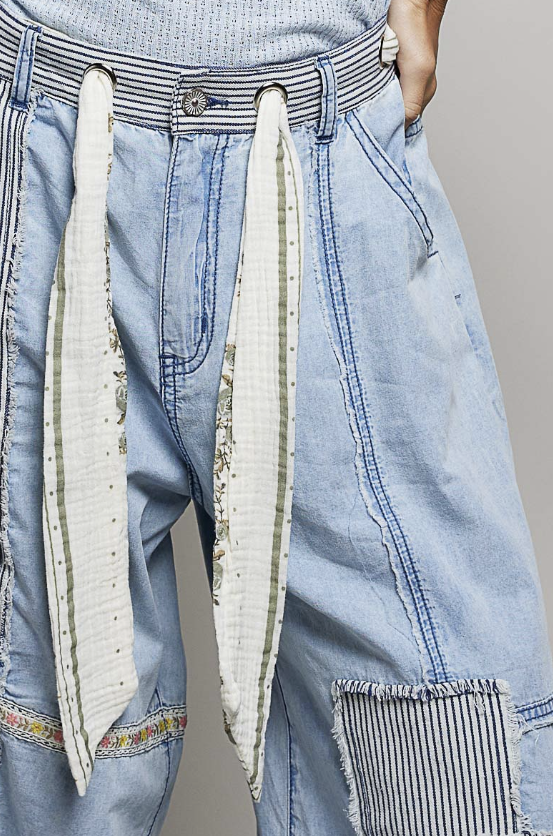 Light blue jeans with decorative elements on a plain background