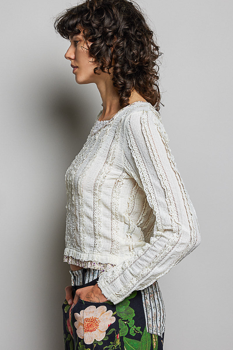 Woman wearing a white lace top with a gray background