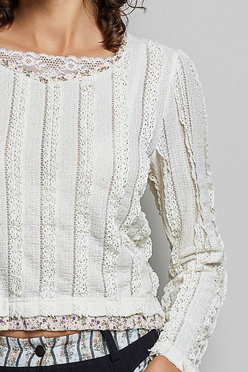 Close-up of a white lace top on a gray background
