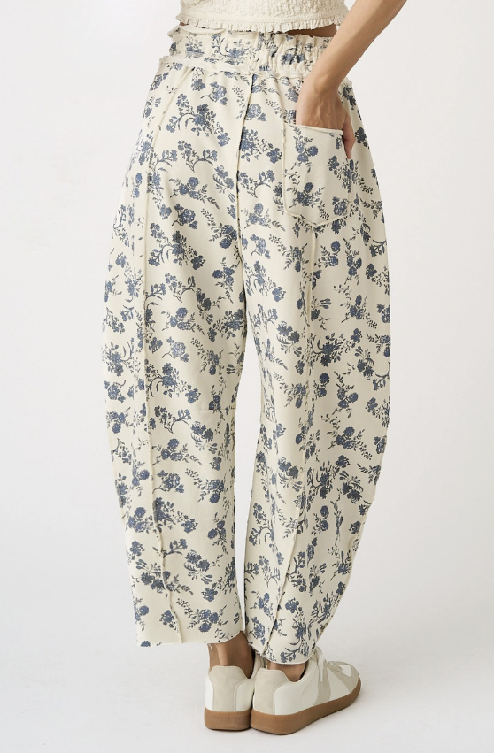 Woman wearing cream floral pants on white background