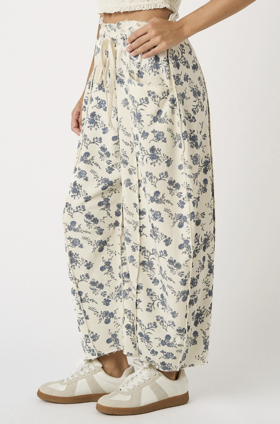 Woman wearing cream floral pants on white background