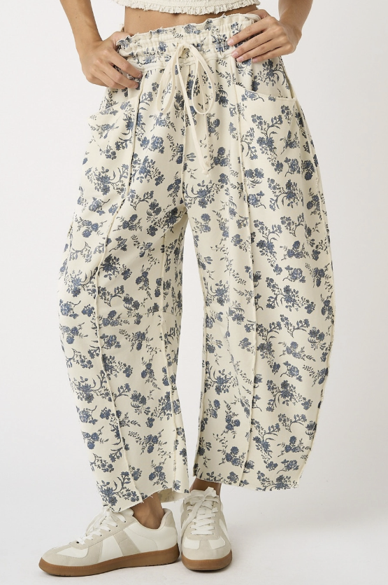 Woman wearing cream floral pants on white background