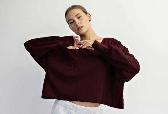 Woman wearing dark cherry long sleeve top  on white background