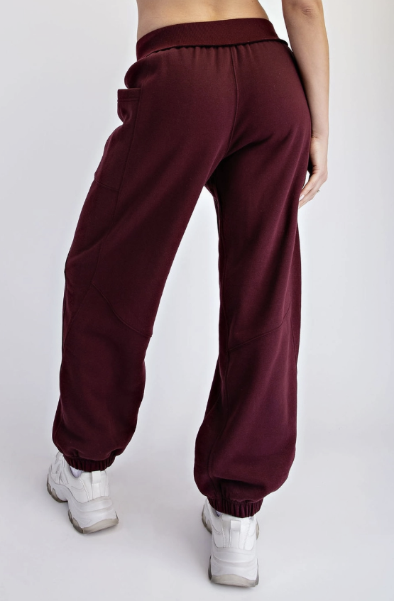 Woman shown from back wearing burgundy jogger sweatpants on white background