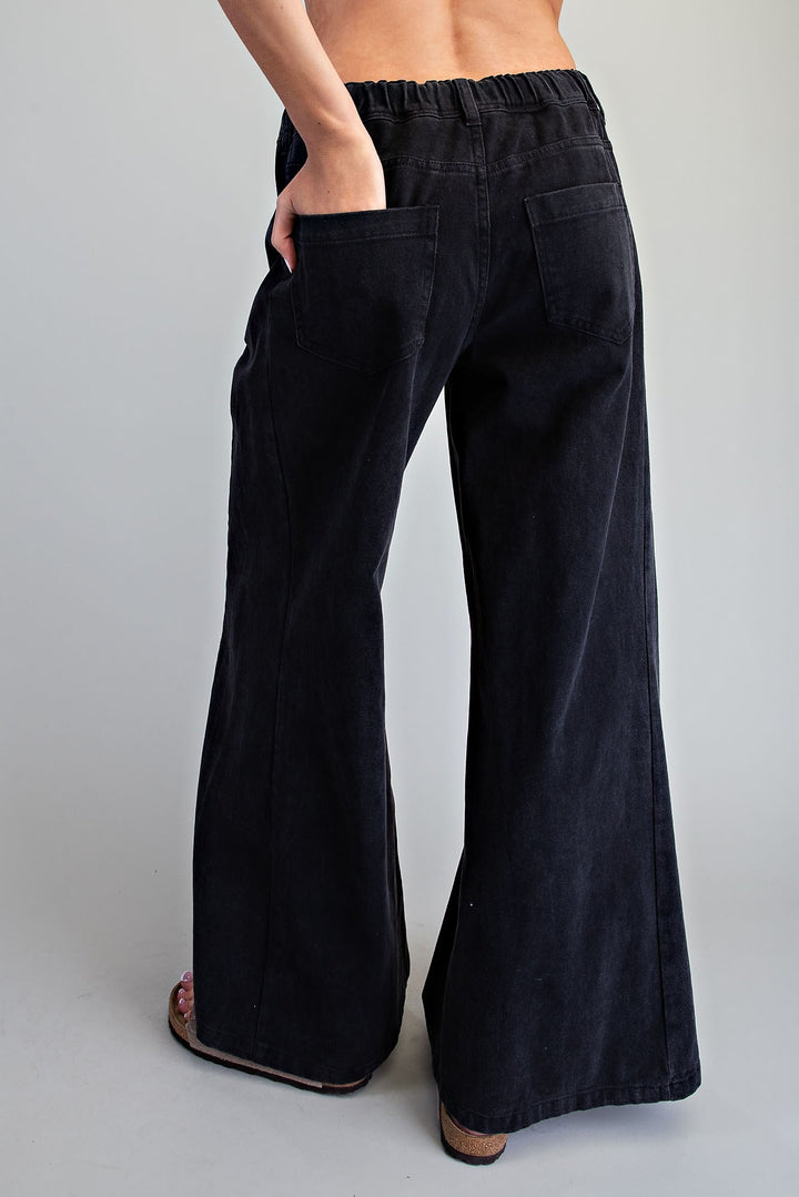 Black wide-leg pants with an elastic waistband, shown from the back on a model against a light gray background.