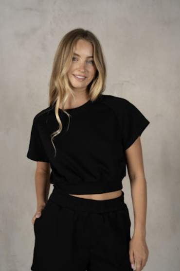 Woman wearing a black outfit against a plain background
