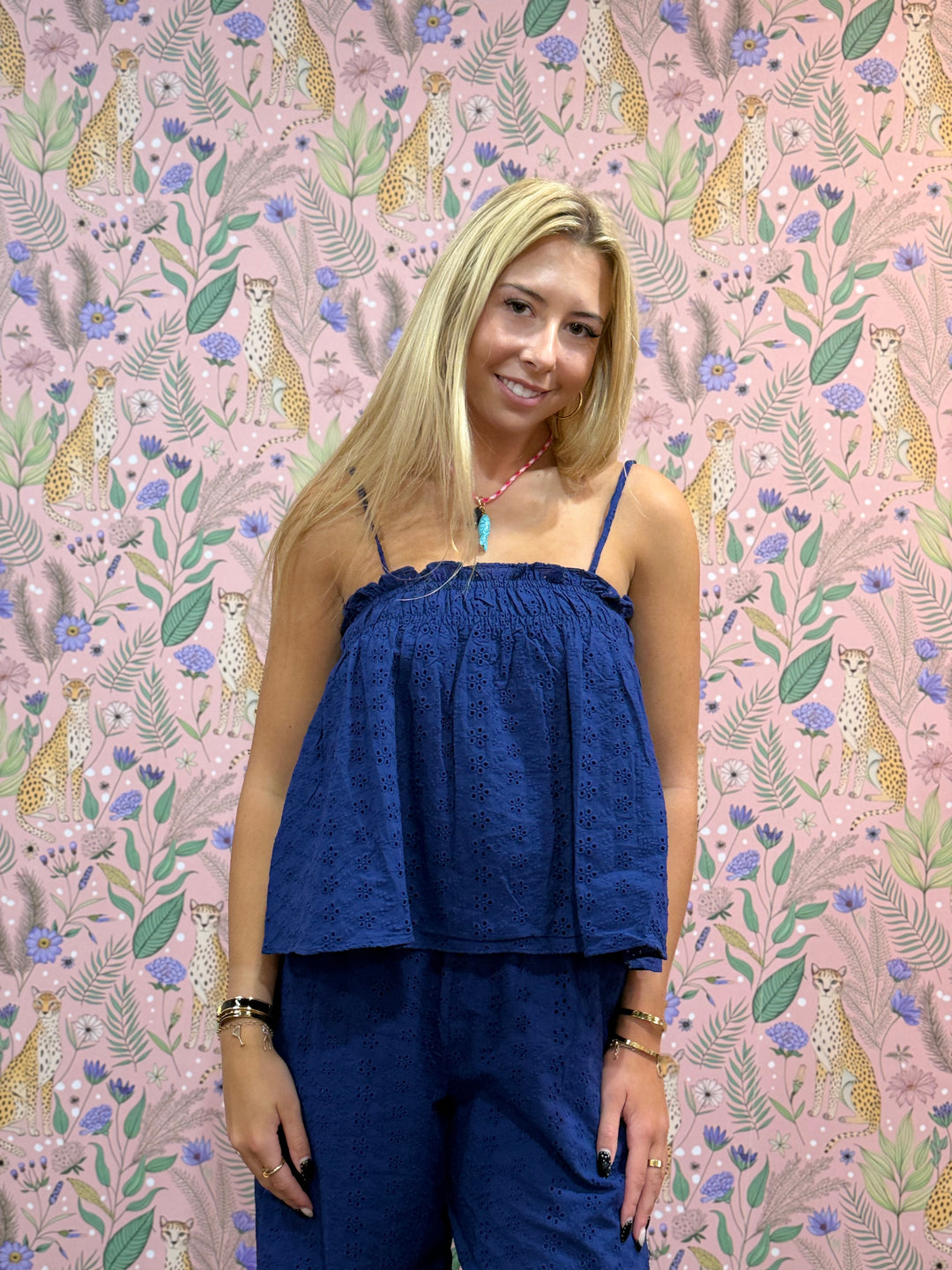 Woman wearing matching blue set on animal print and floral background