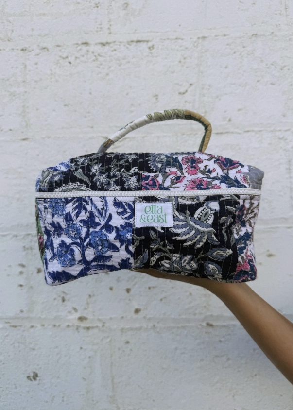Quilted makeup bag with multiple paisley designs outdoors on brick wall