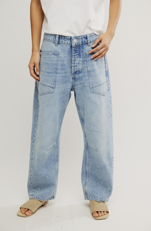Person wearing light blue jeans on a plain background