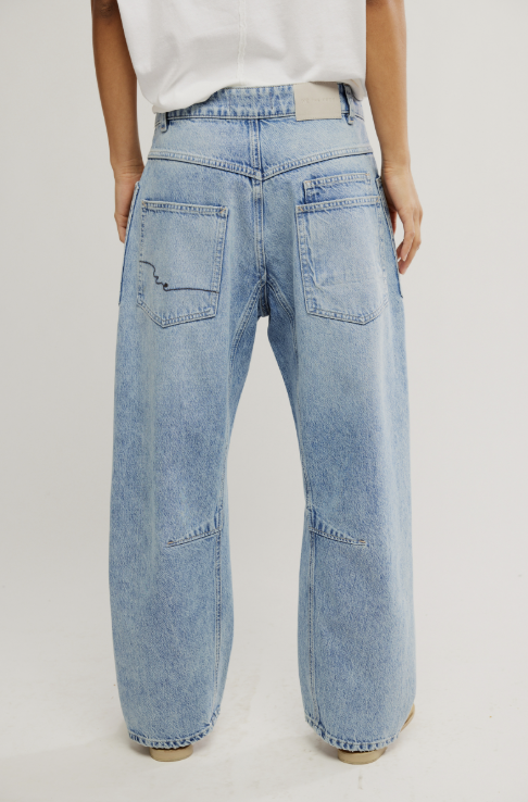 Light blue jeans worn by a person on a plain background