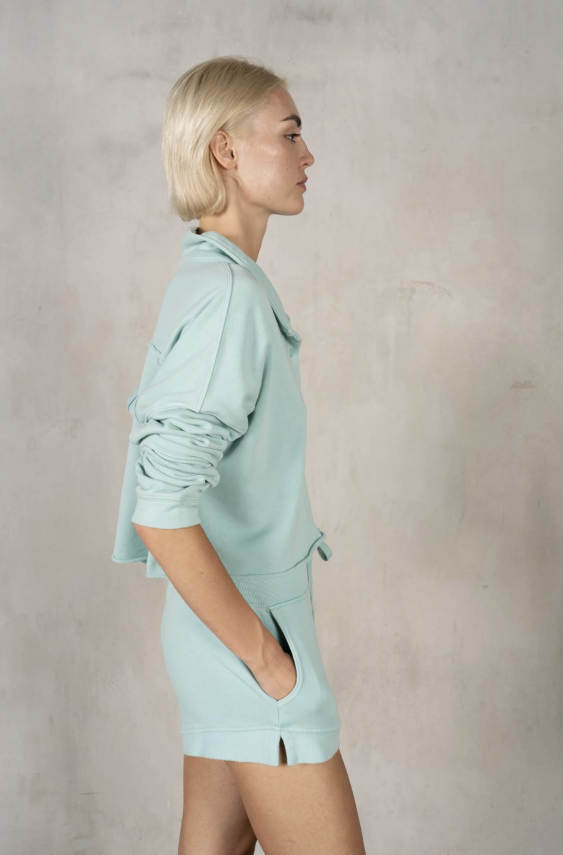 Woman wearing a light blue outfit against a plain background