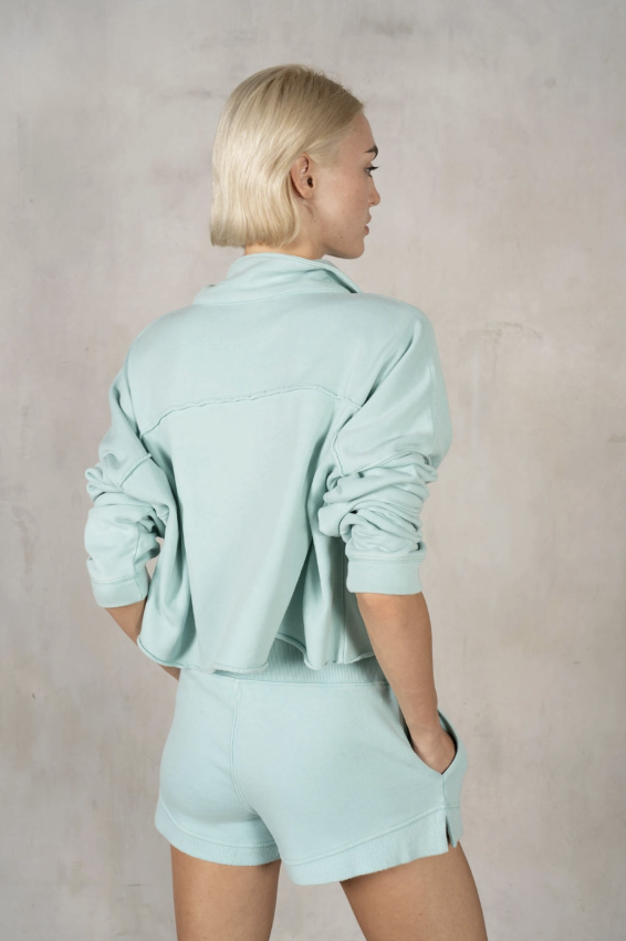 Person wearing a light blue outfit against a plain background