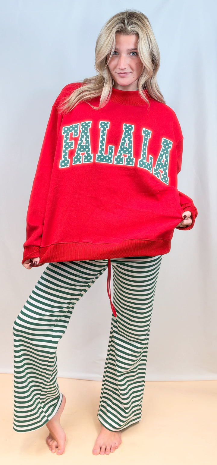 Woman wearing red mock neck sweatshirt with &