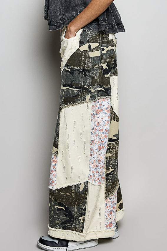 Person wearing a patchwork skirt with various patterns on a plain background