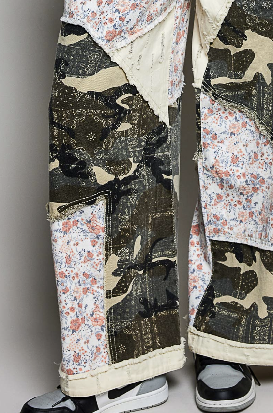 Close up of camouflage pants with floral pattern on plain background