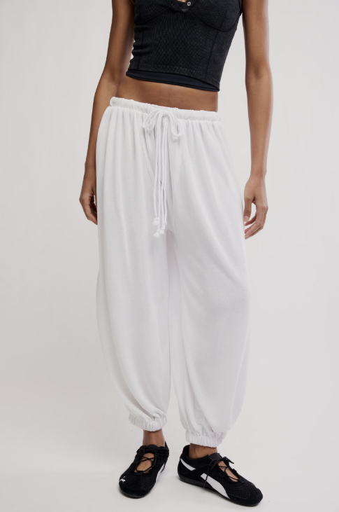 White pants worn by a person on a plain background