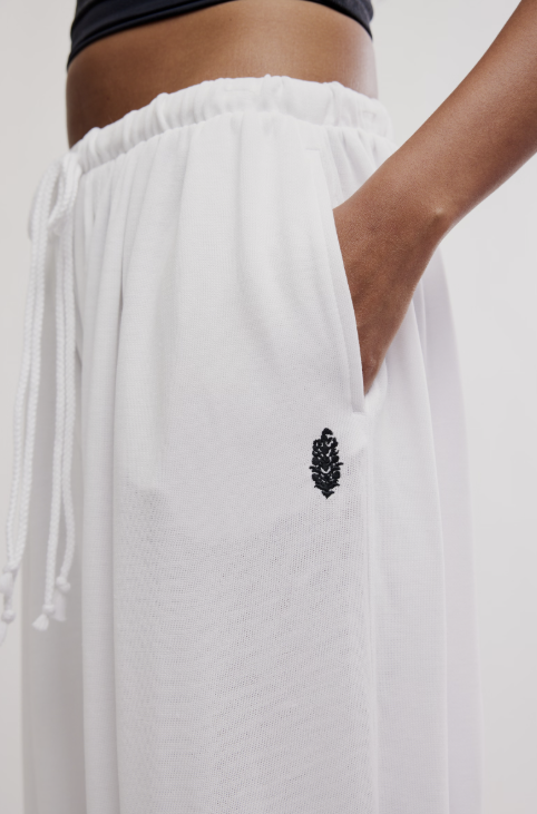 White pants with a black embroidered design on a plain background