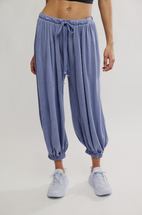 Person wearing blue drawstring pants on a plain background