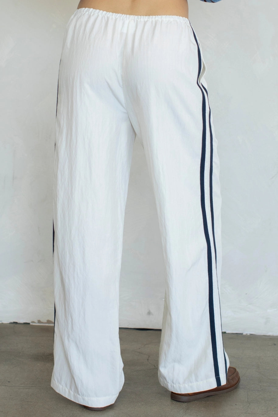 White pants with black stripes on a plain background