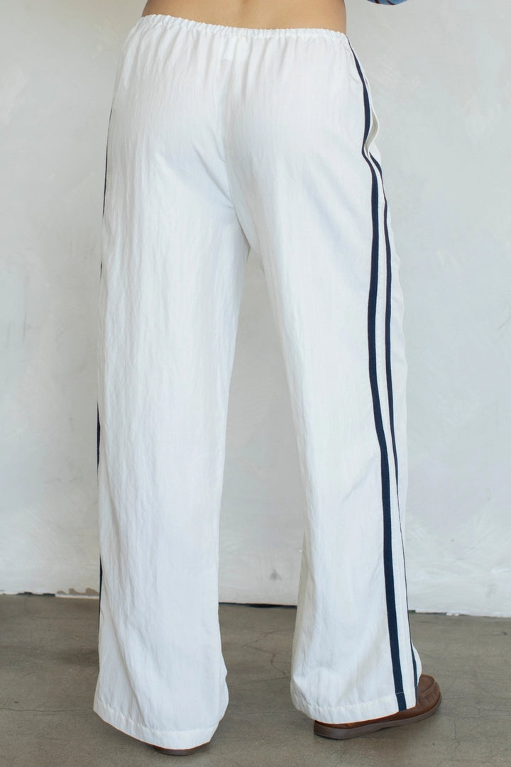 White pants with black stripes on a plain background