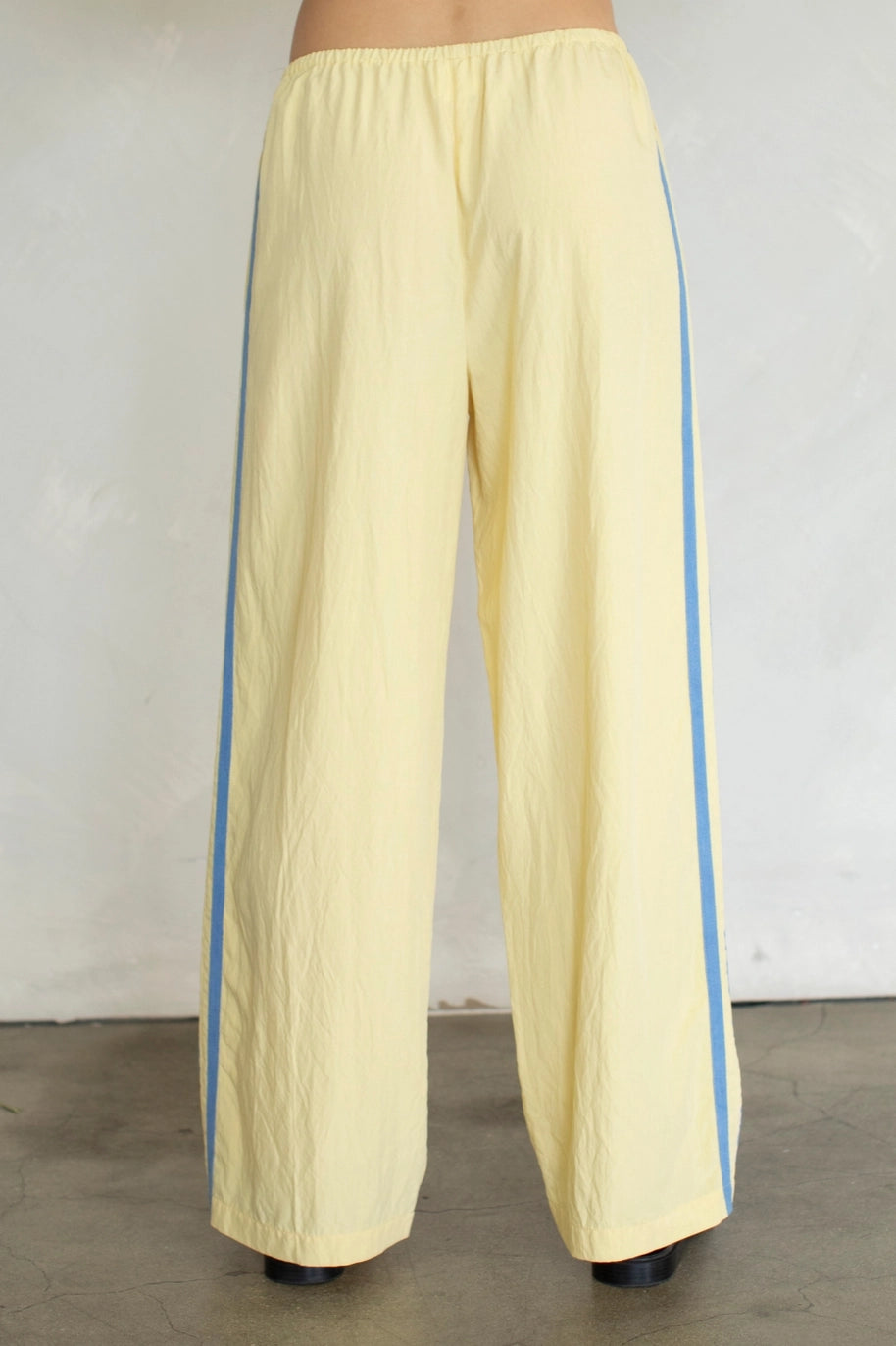 Yellow pants with blue stripes on a plain background